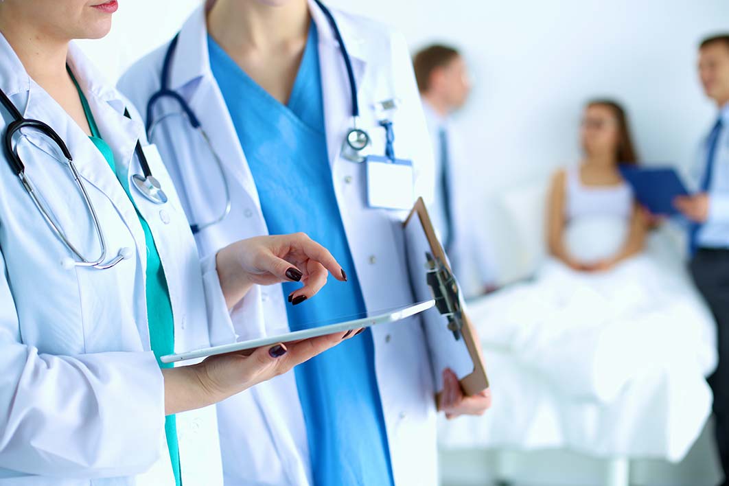 A physician reviewing a patient chart during an independent exam.